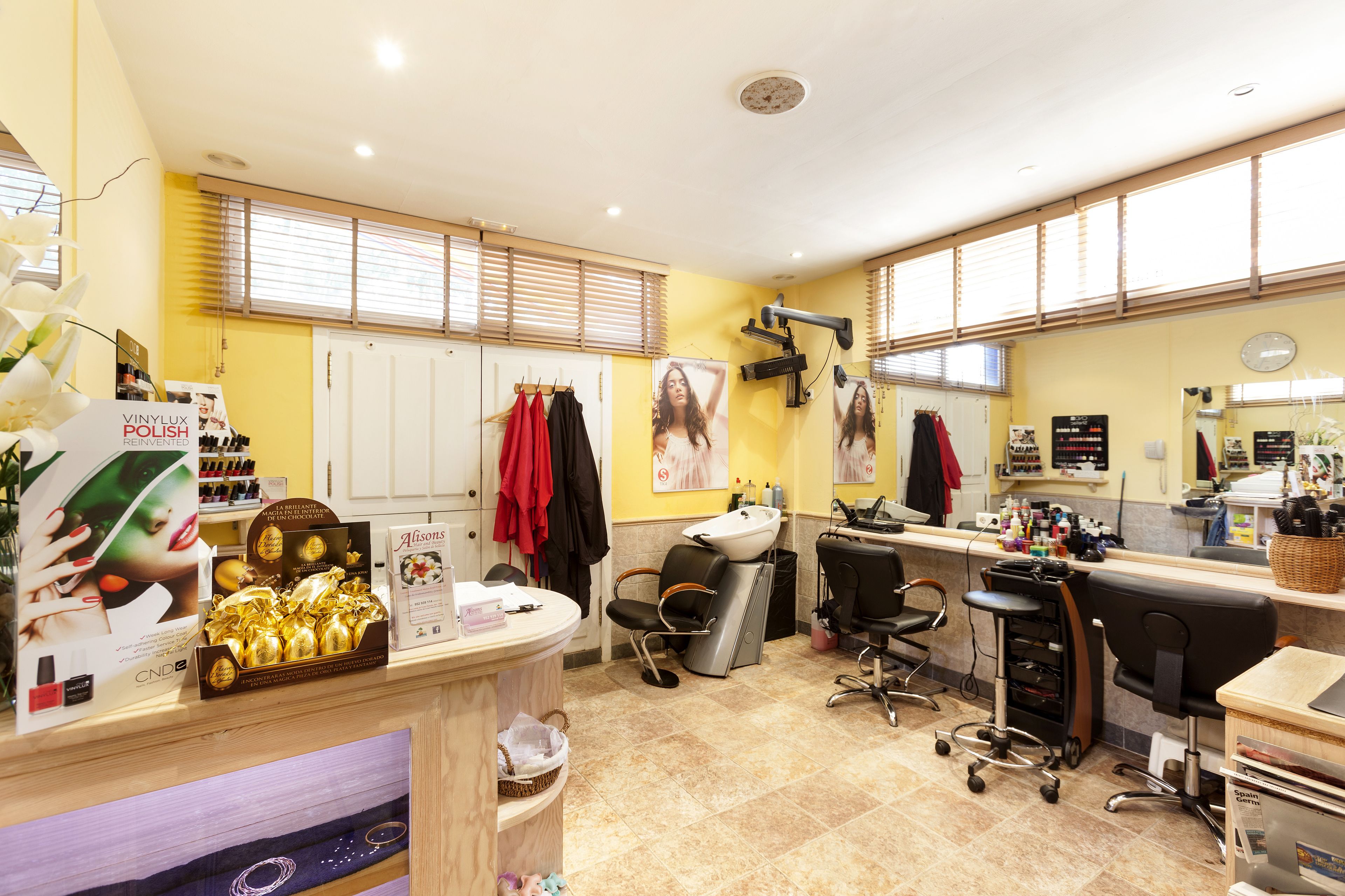 A salon with a reception area, chairs, and various beauty products on display.