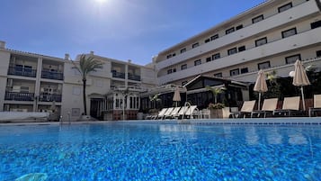 Een binnenzwembad, een buitenzwembad en ligstoelen