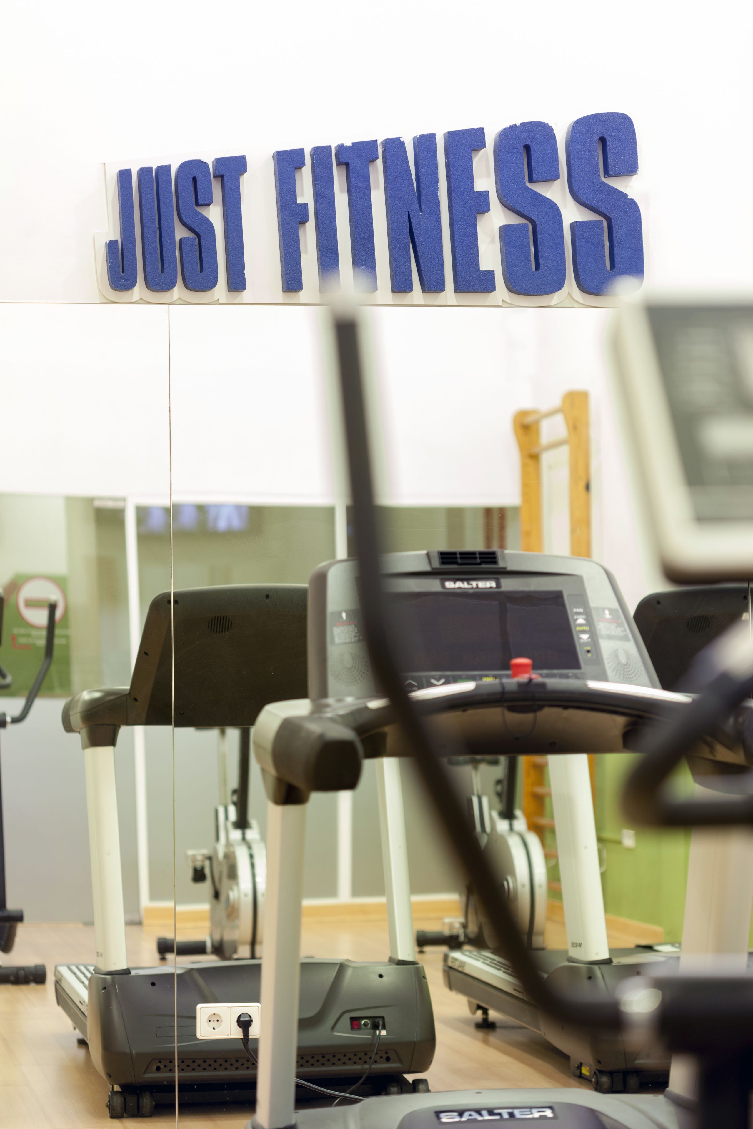 A gym with treadmills and a sign that reads "JUST FITNESS".