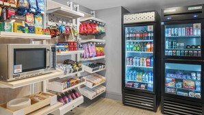 A vending area with microwaves, snack bags, and refrigerated beverage dispensers. - Spark by Hilton St. Augustine Historic District (St. Augustine)