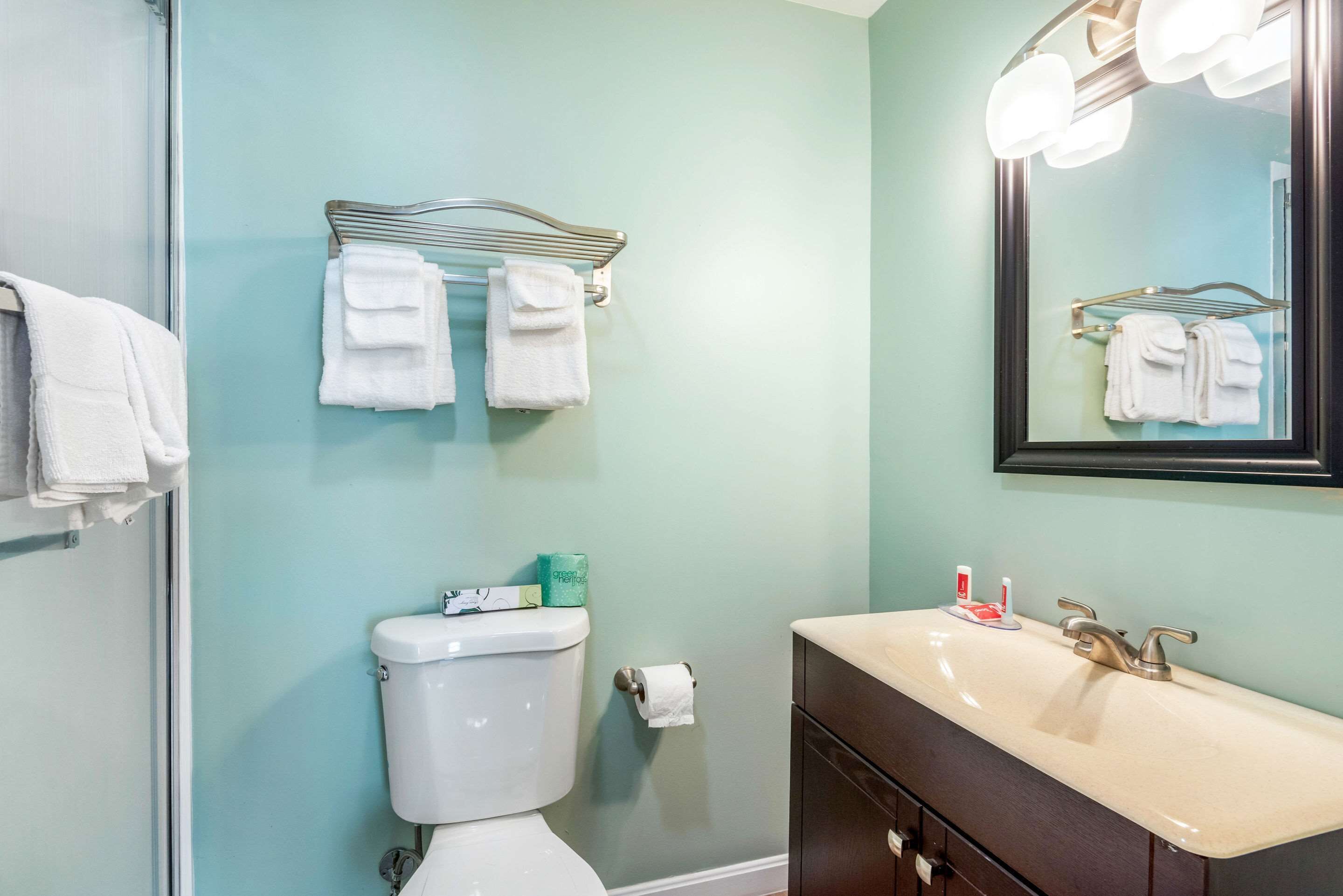 Une salle de bain équipée de toilettes, d’un lavabo et d’un porte-serviettes.