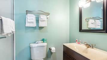 Un baño con inodoro, lavamanos y perchero para toallas.