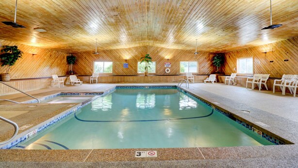 An indoor swimming pool with a wooden ceiling, lounge chairs, and a sign indicating a 3ft depth. - Quality Inn & Suites Lincoln I-93 (Lincoln)