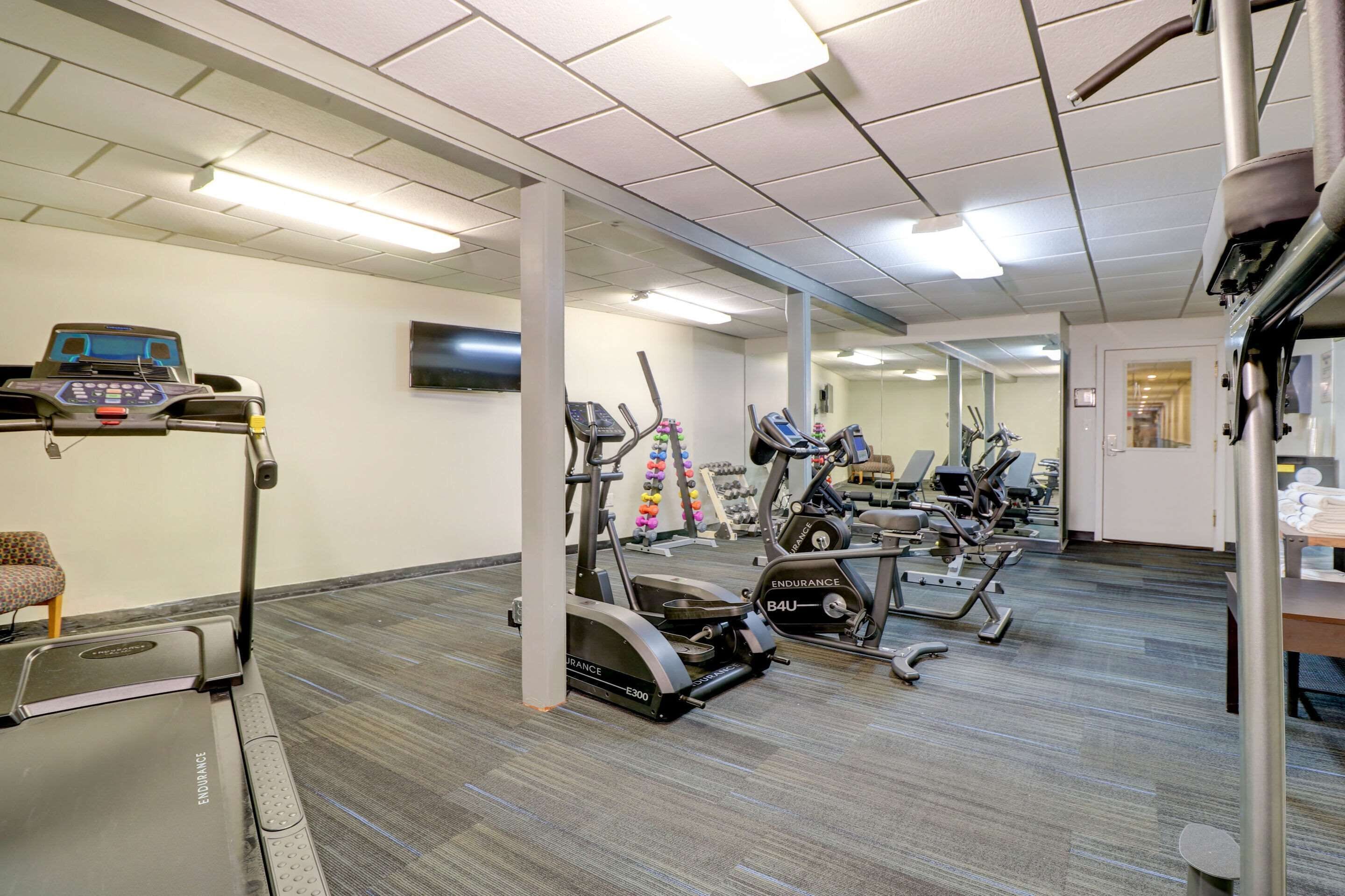 A gym with treadmills, stationary bikes, and a weight machine.