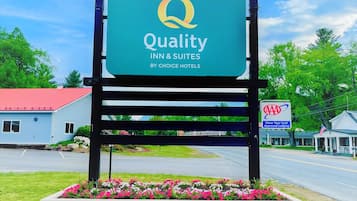 Welcome to Quality Inn & Suites, situated near a scenic road with a beautiful building in the background.