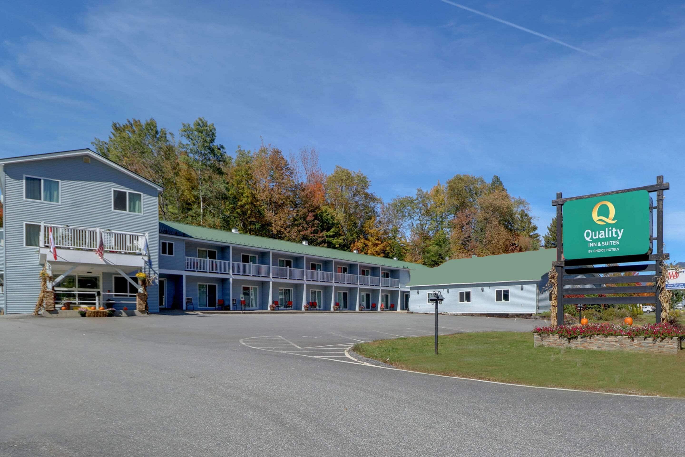 Un motel con un letrero verde que dice 'Quality Inn & Suites by Choice Hotels'.