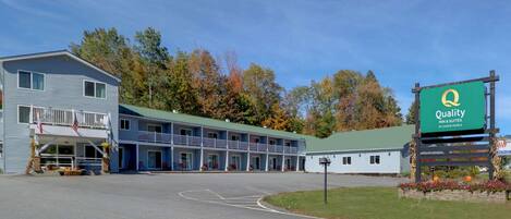 Un motel con un letrero verde que dice 'Quality Inn & Suites by Choice Hotels'.