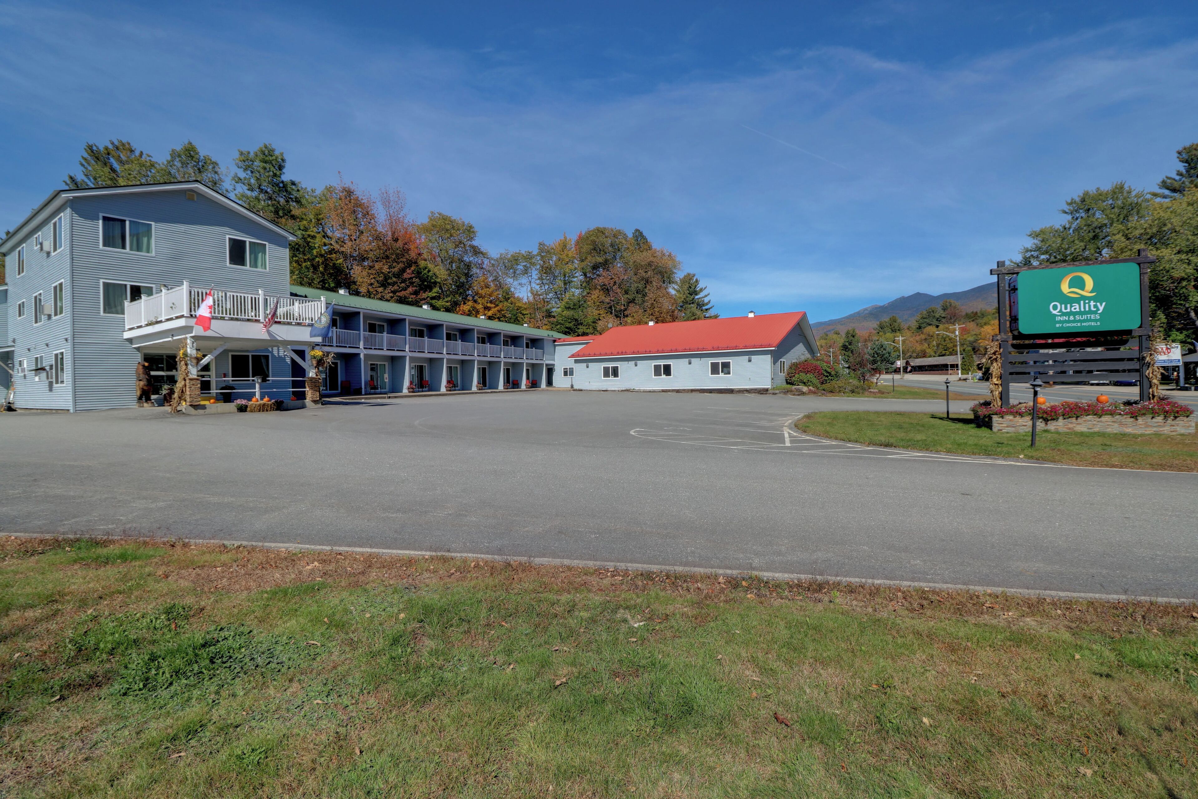 A motel with a red roof, a balcony, and a sign indicating it is a Quality Inn by Choice Suites.