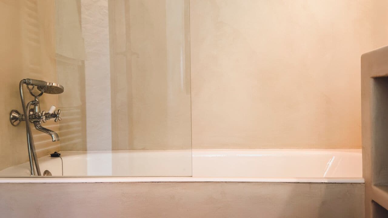 A modern bathroom with a large bathtub, a showerhead, and a glass-enclosed shower area.