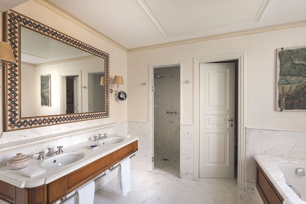 Un baño con dos lavabos, un espejo grande y una ducha.