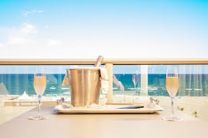 A table with a champagne bucket and two glasses, overlooking a beach with a clear sky. - Grand Hotel les Flamants Roses (Canet-en-Roussillon)