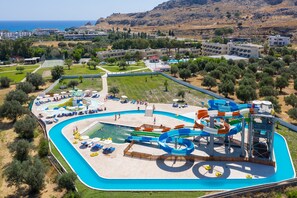 A water park with multiple slides and a pool area, surrounded by greenery and buildings. - Olive Garden Hotel (Rhodes)