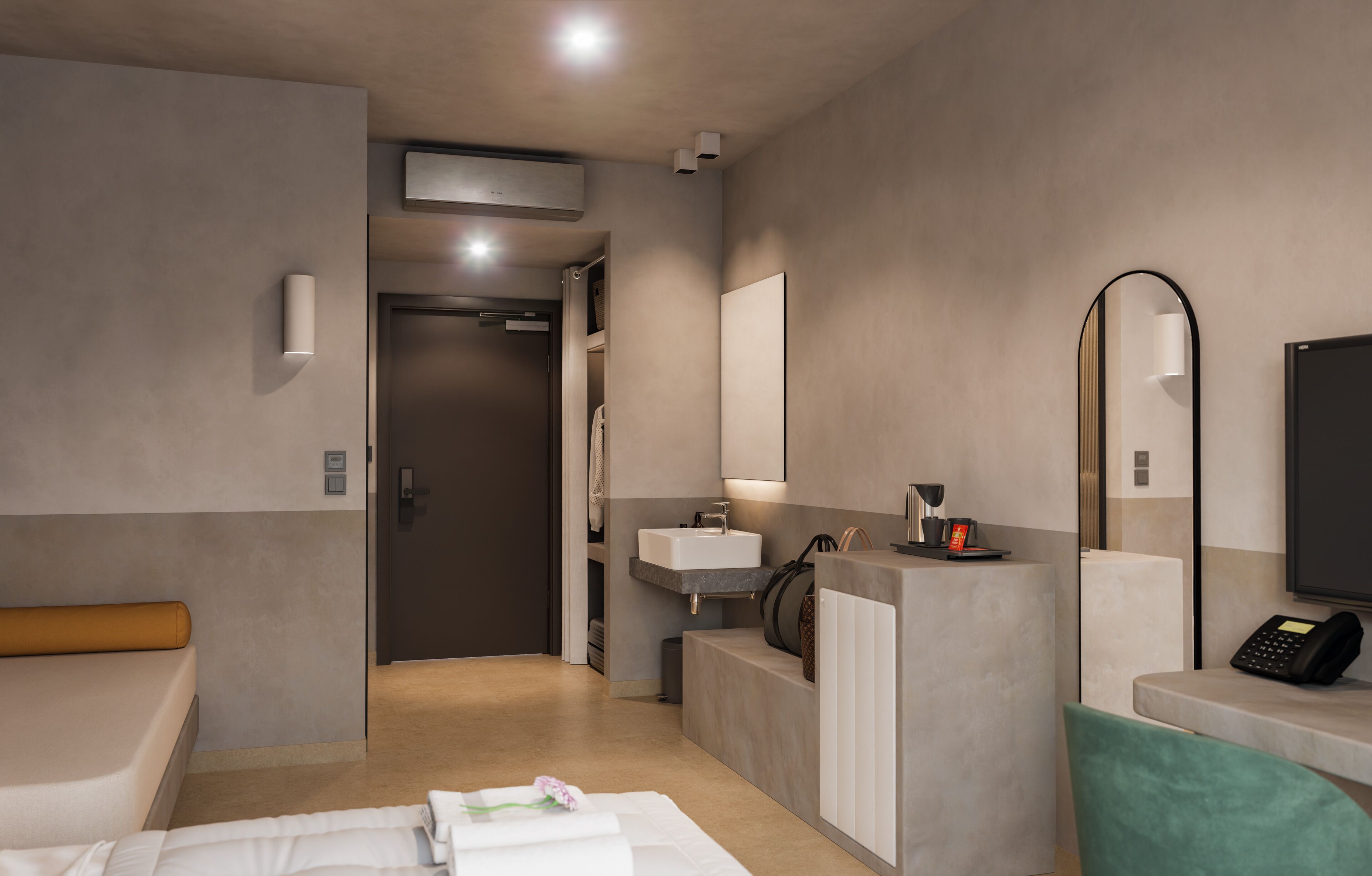 A modern hotel room with a bed, a desk, a mirror, a sink, and a telephone.