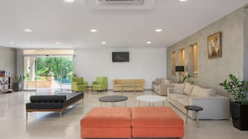 A spacious living area with a sofa, ottomans, and a coffee table.
