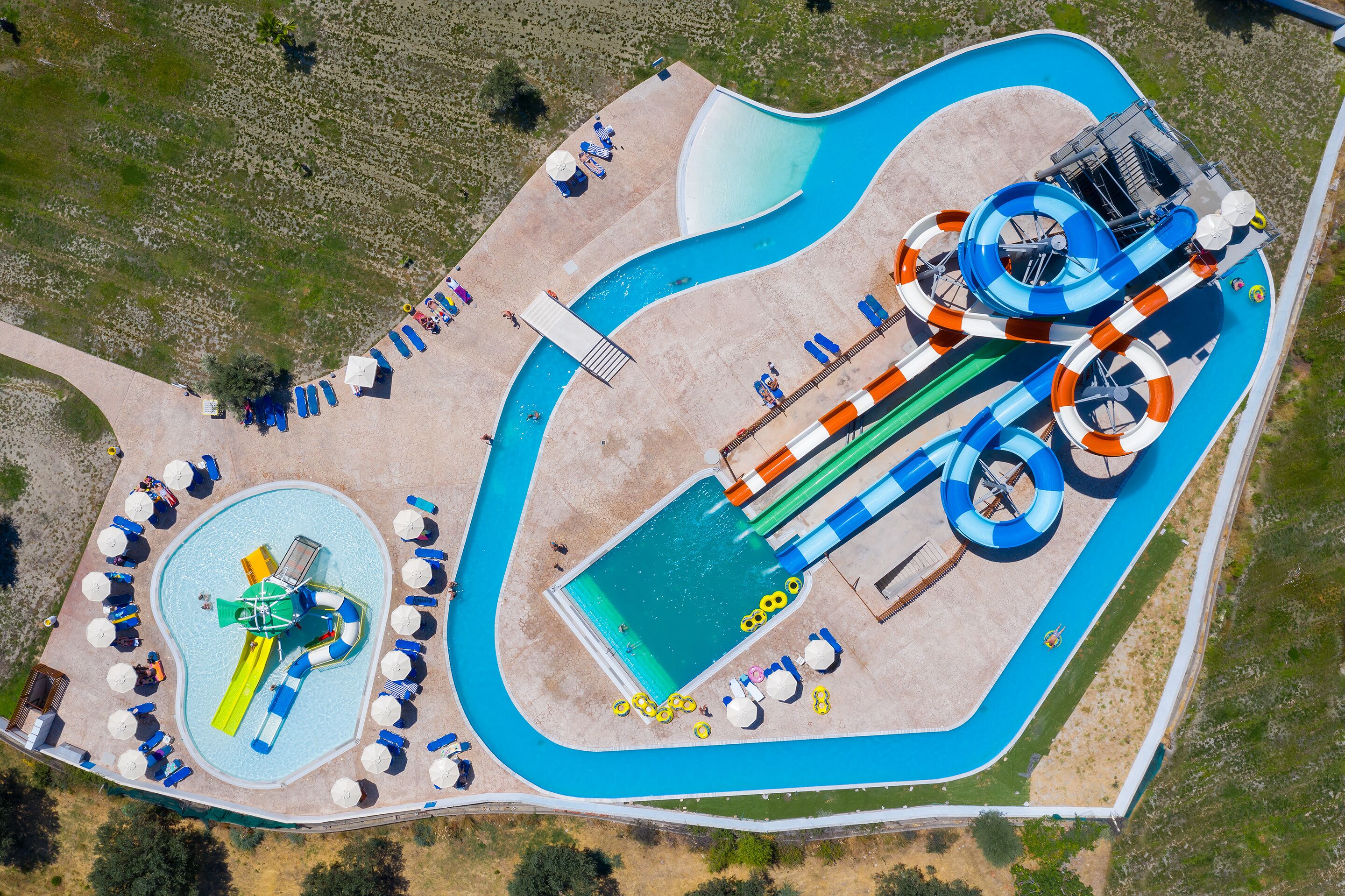 Eine Vogelperspektive eines Wasserparks mit großem Pool, mehreren Wasserrutschen und einem Wellenbecken.
