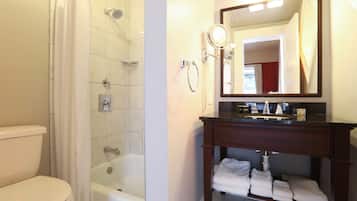 A bathroom with a shower, toilet, bathtub, and a vanity with a mirror and towel rack.