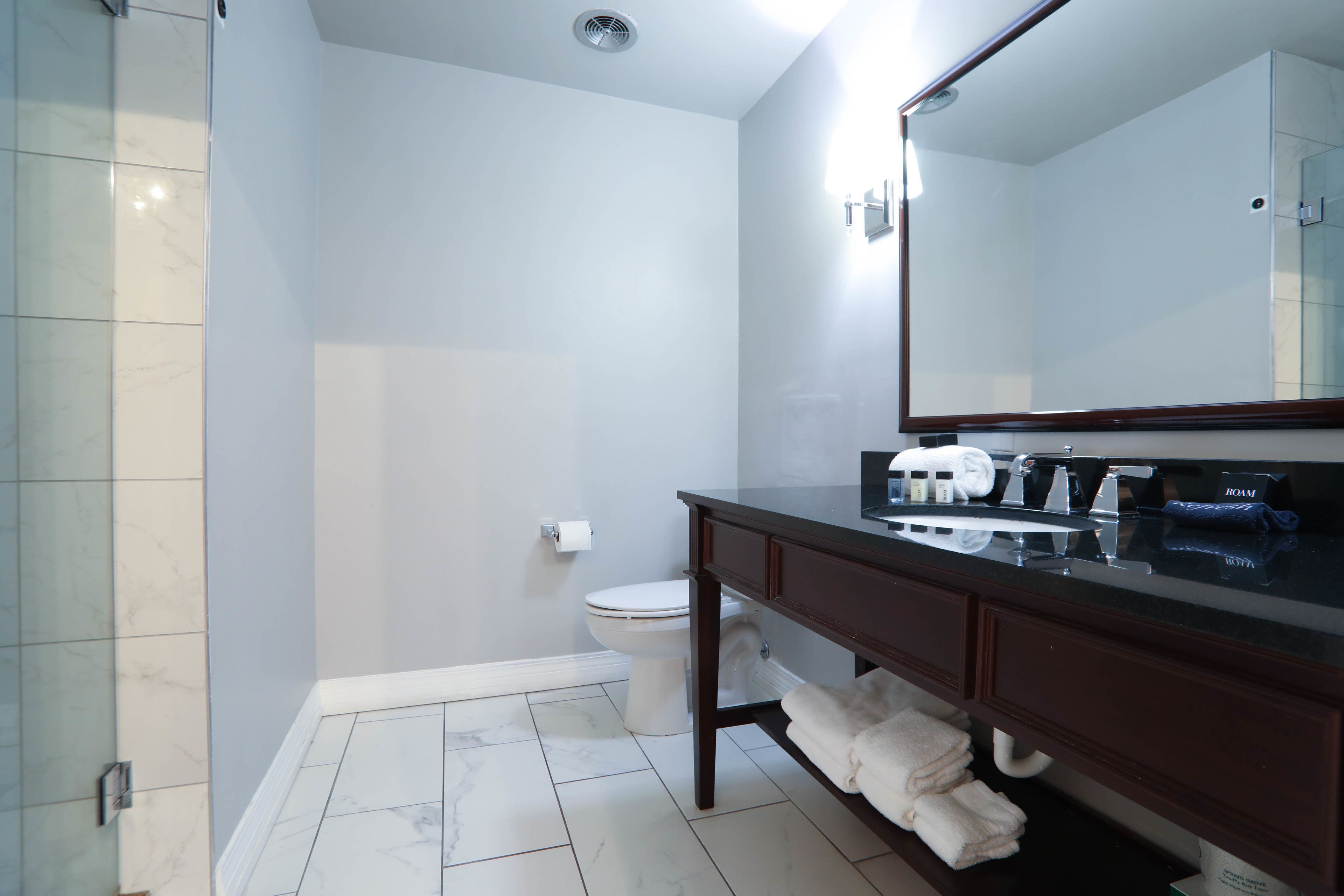 Une salle de bain moderne équipée d’une douche, de toilettes et d’un meuble-lavabo.