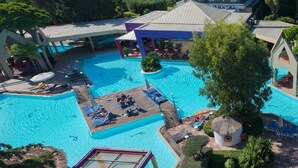 A large outdoor swimming pool with multiple sunbathing areas and lounge chairs. - Dionysos Hotel (Rhodes)