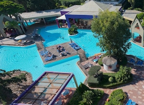 A large outdoor swimming pool with multiple sunbathing areas and lounge chairs.