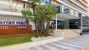 A hotel entrance with a modern facade, palm trees, and a clear view of the building's exterior. - Hotel RH Bayren Parc By Hoteles RH (Gandia)