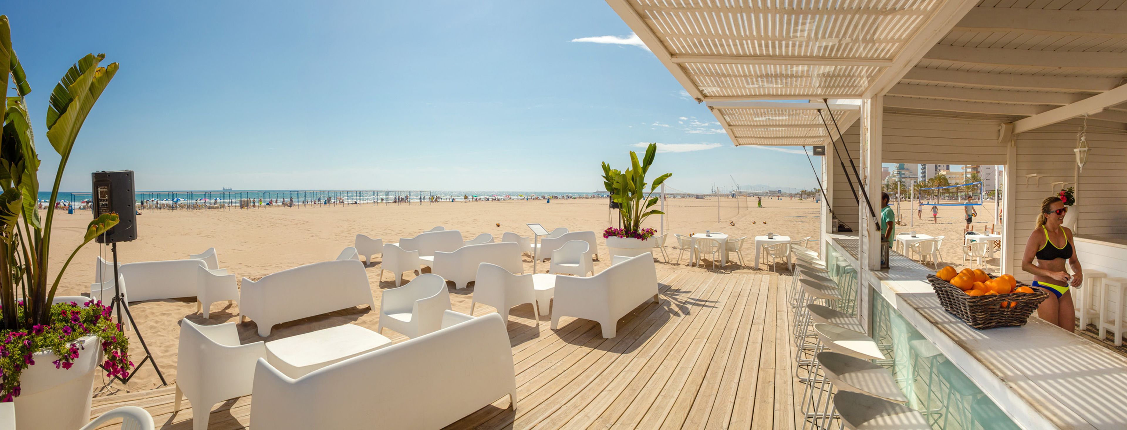 Un restaurant situé en bord de mer, avec une terrasse, une vue sur la plage et un bar où l’on sert des fruits.