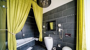 Uma casa de banho moderna com uma banheira, uma grande pia branca, uma sanita e um espelho.