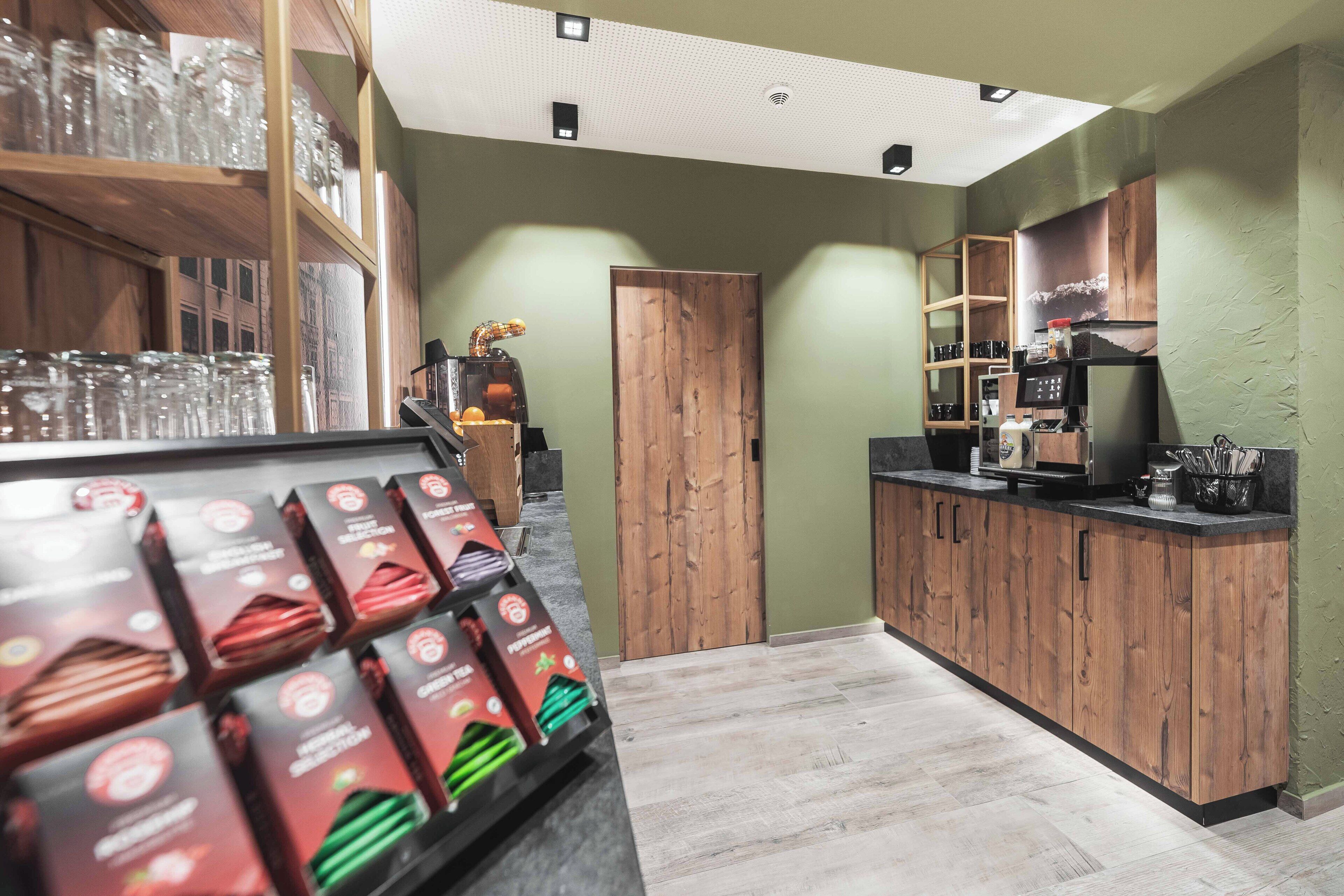 Een moderne keuken met houten kastjes, een koffieapparaat en een presentatie van verpakte producten.