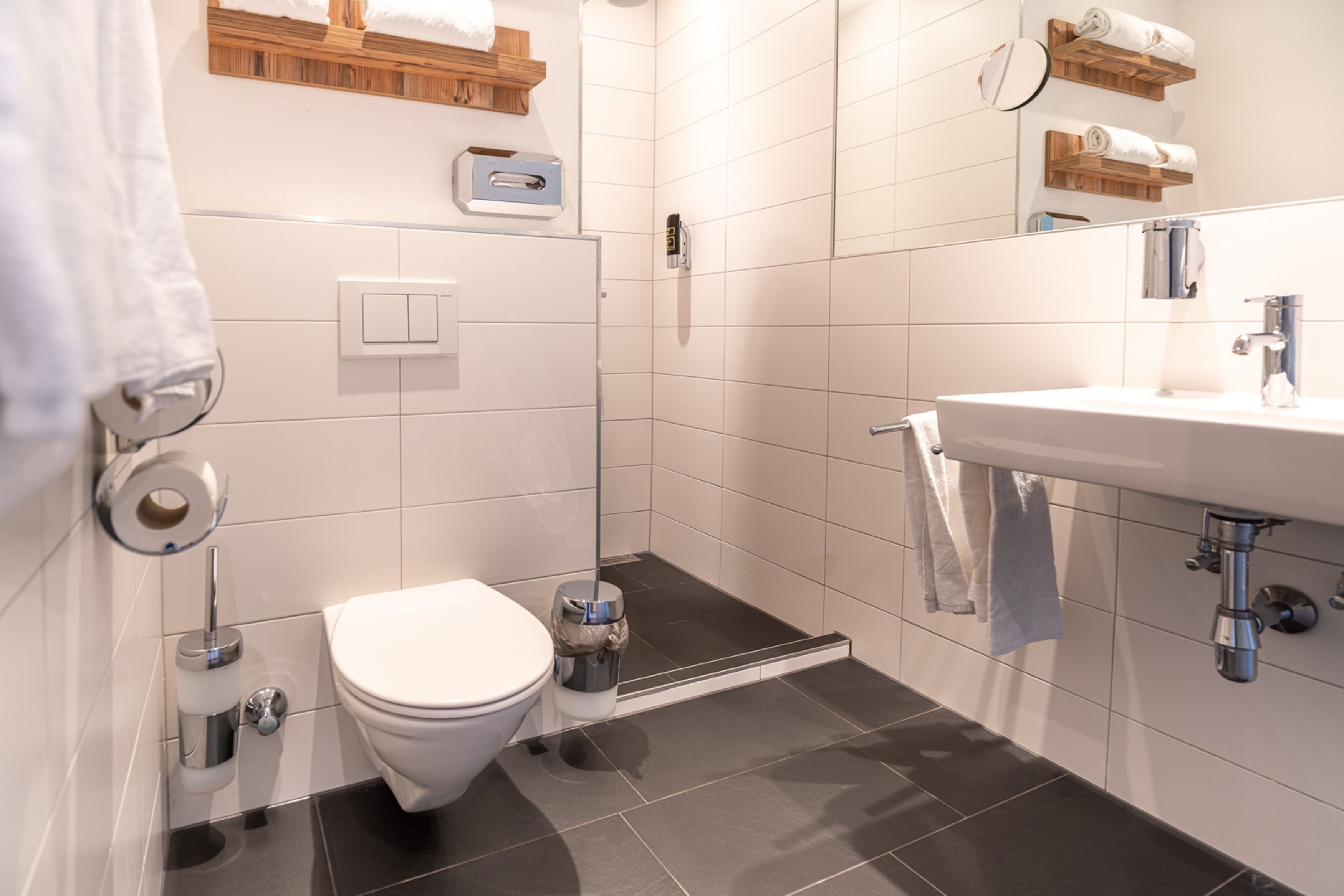A modern bathroom with a toilet, bidet, and sink.