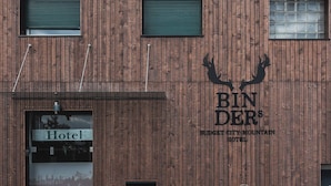 Een houten gebouw met een bord waarop 'BIN DER BUDGET CITY MOUNTAIN HOTEL' staat.