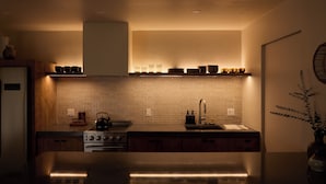 A modern kitchen with a central island, a stove, and a sink. - Los Bungalows (Imperial Beach)