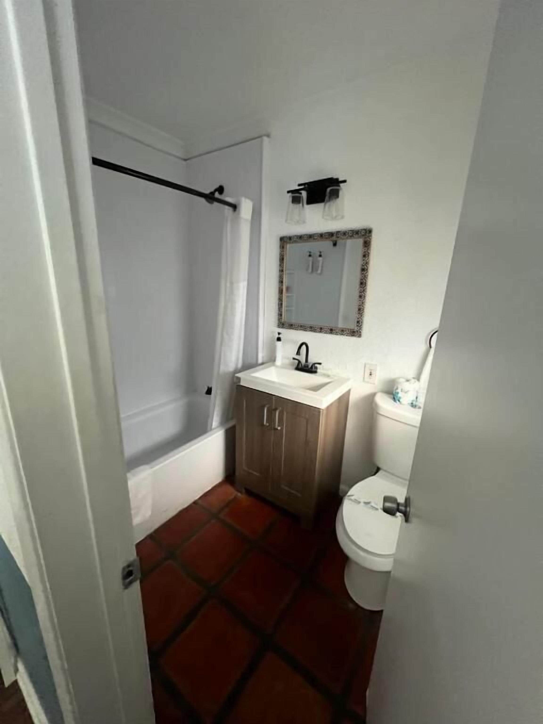 Ein kleines Badezimmer mit Dusche, Toilette und Waschbecken.