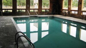 Una piscina interior con vistas despejadas de los alrededores gracias a amplias ventanas.