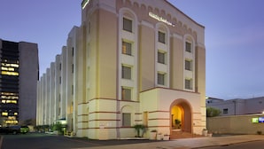 A large, multi-story building with a prominent arched entrance and a sign reading "Holiday Inn Express." - Holiday Inn Express San Antonio N-Riverwalk Area by IHG (San Antonio)