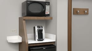 A kitchenette with a microwave, coffee maker, and dishwasher.