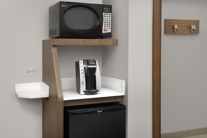 Una kitchenette equipada con microondas, cafetera y lavavajillas.