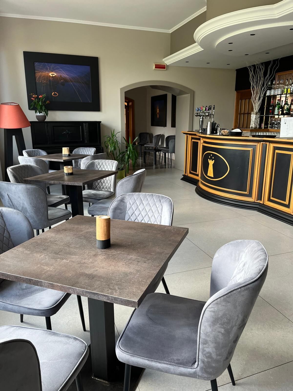 A modern bar area with a bar counter, seating, and a television screen.
