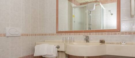 A bathroom with a toilet, sink, and mirror.