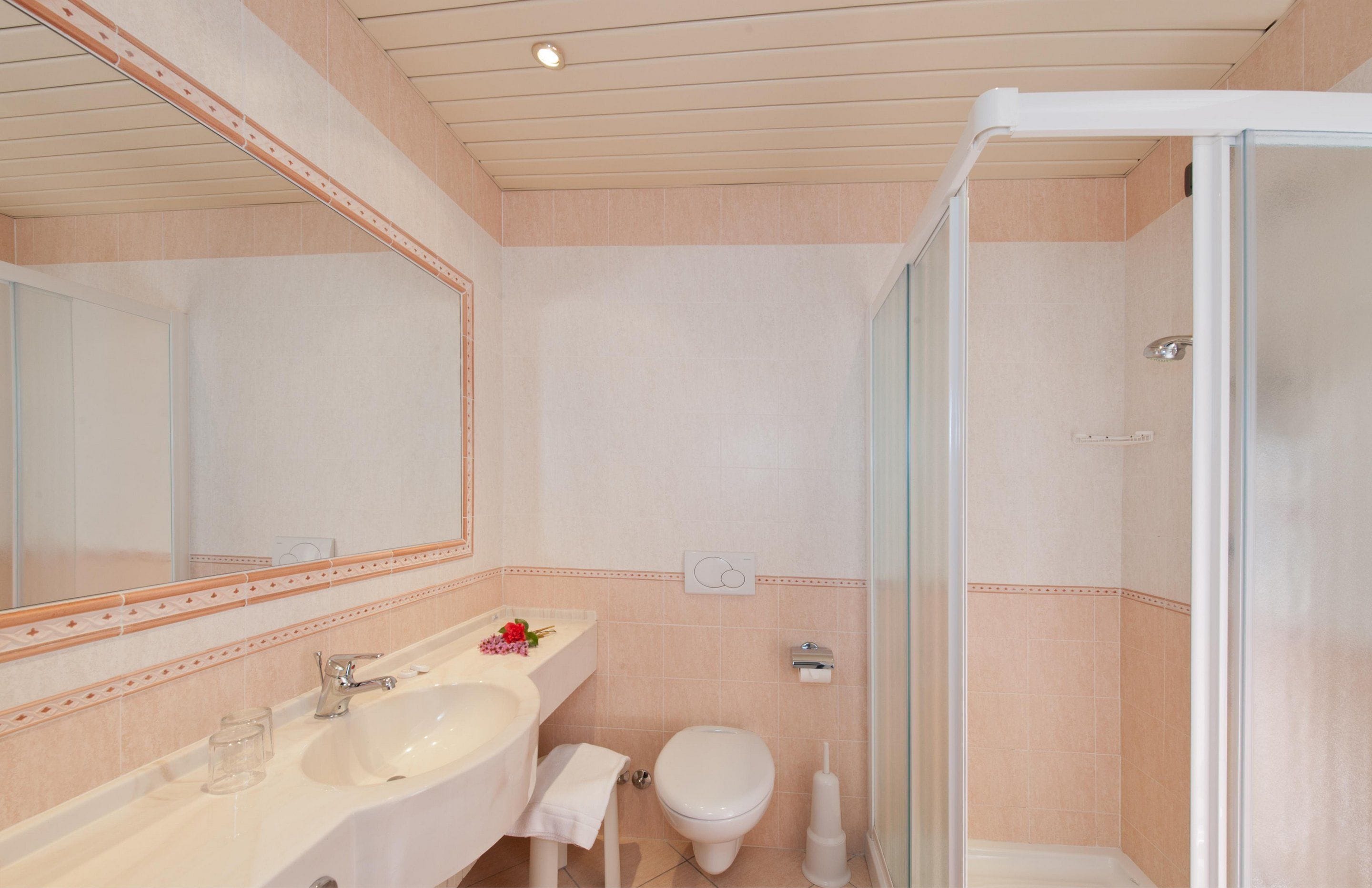 A bathroom with a sink, toilet, and shower.