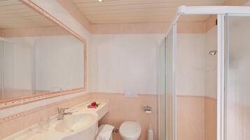 A bathroom with a sink, toilet, and shower.