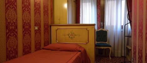 A room with a bed, a wardrobe, a chair, and a desk.