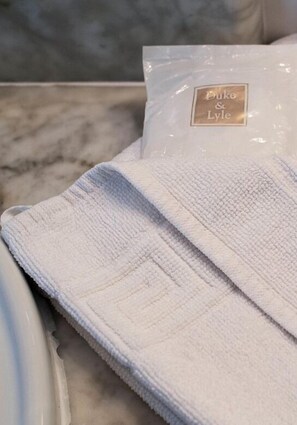 A white towel with a Duke & Lyle label on a marble surface.