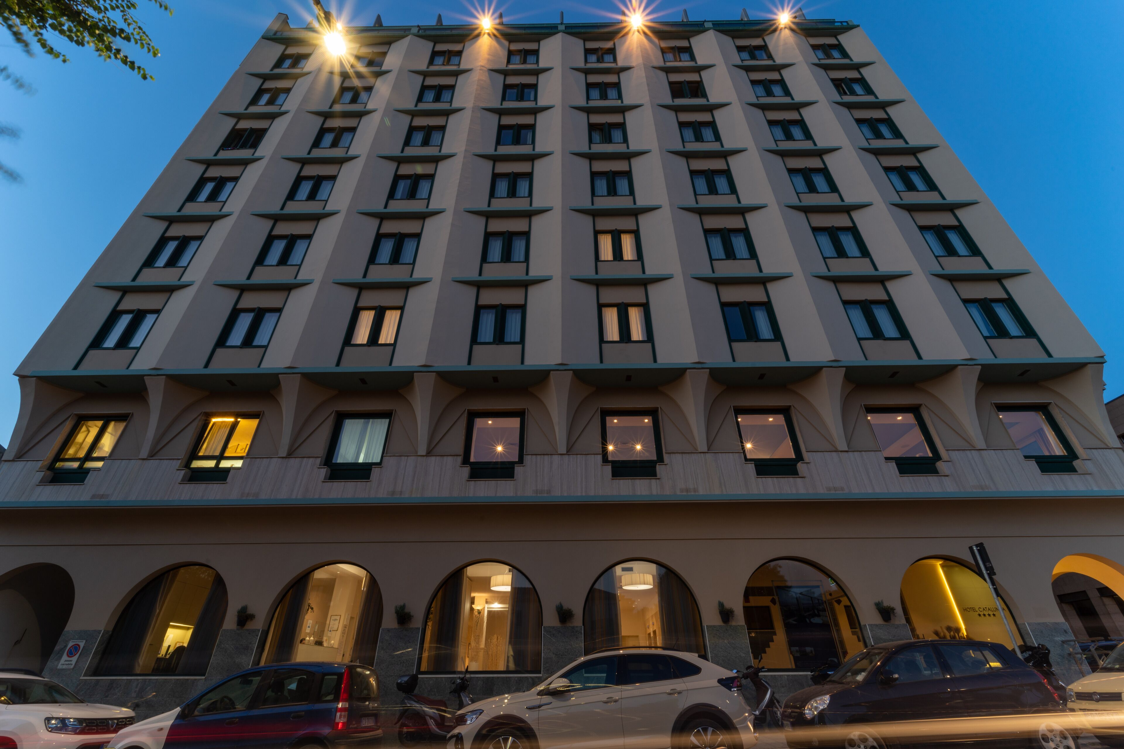 A multi-story hotel with a symmetrical facade, large windows, and a central entrance with arched doorways.