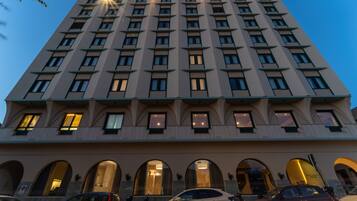 A multi-story hotel with a symmetrical facade, large windows, and a central entrance with arched doorways.