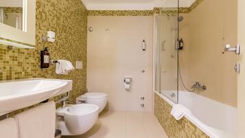 A bathroom with a sink, toilet, bidet, and bathtub.