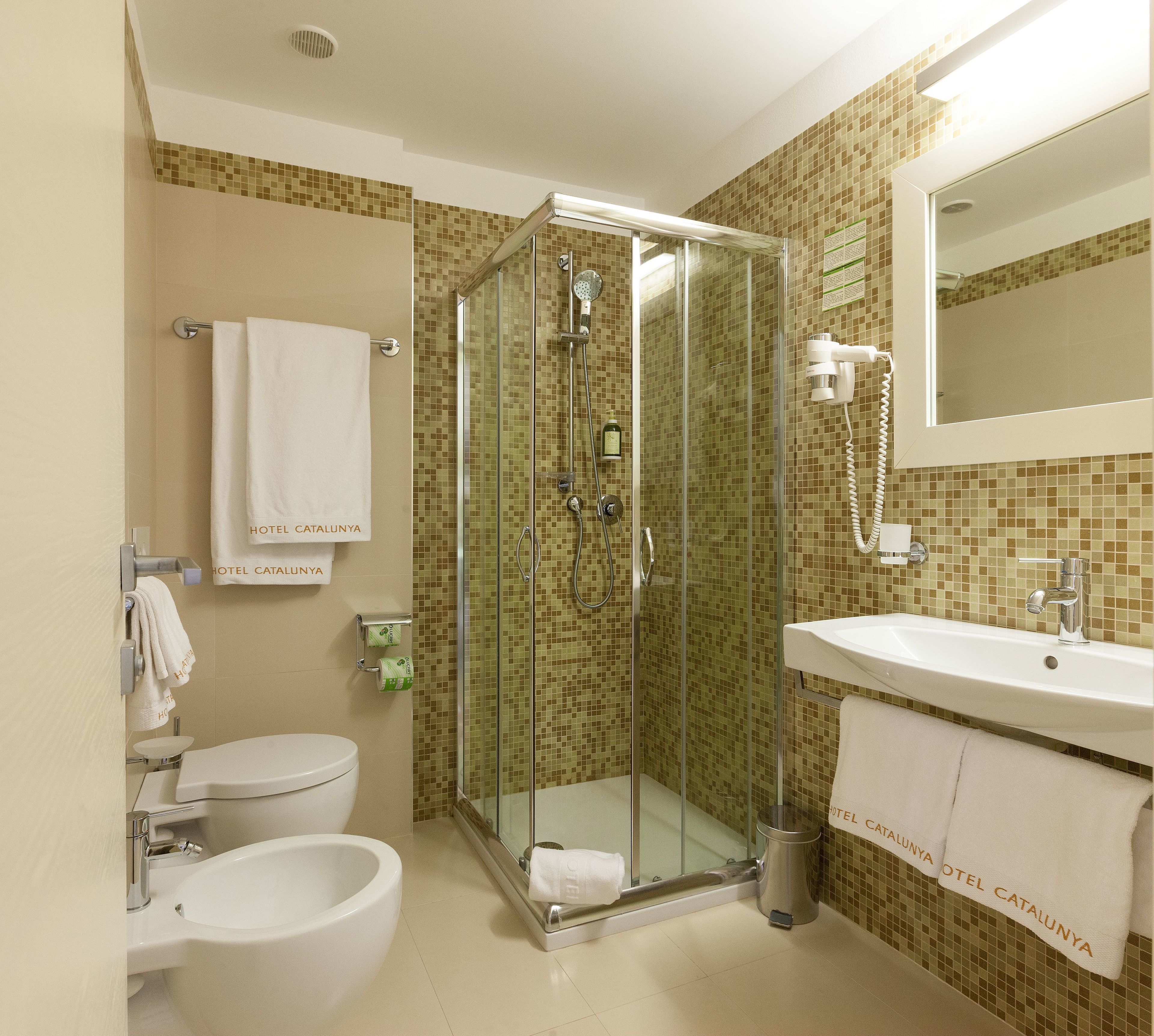 Un bagno con doccia vetro, un water e un lavandino.