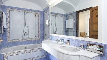 Un bagno con una vasca da bagno ampia, due lavandini e uno specchio.