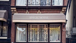 A hotel facade with a double balcony, large windows, and a sign reading "SINGEL HOTEL." - Singel Hotel Amsterdam (Amsterdam)