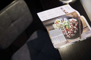 Un magazine ou une brochure sur une table, avec une photo d’un plat et du texte.