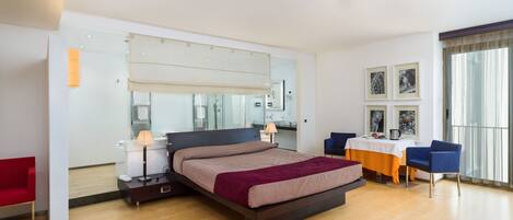 Un dormitorio moderno con una cama grande, un escritorio y una silla.