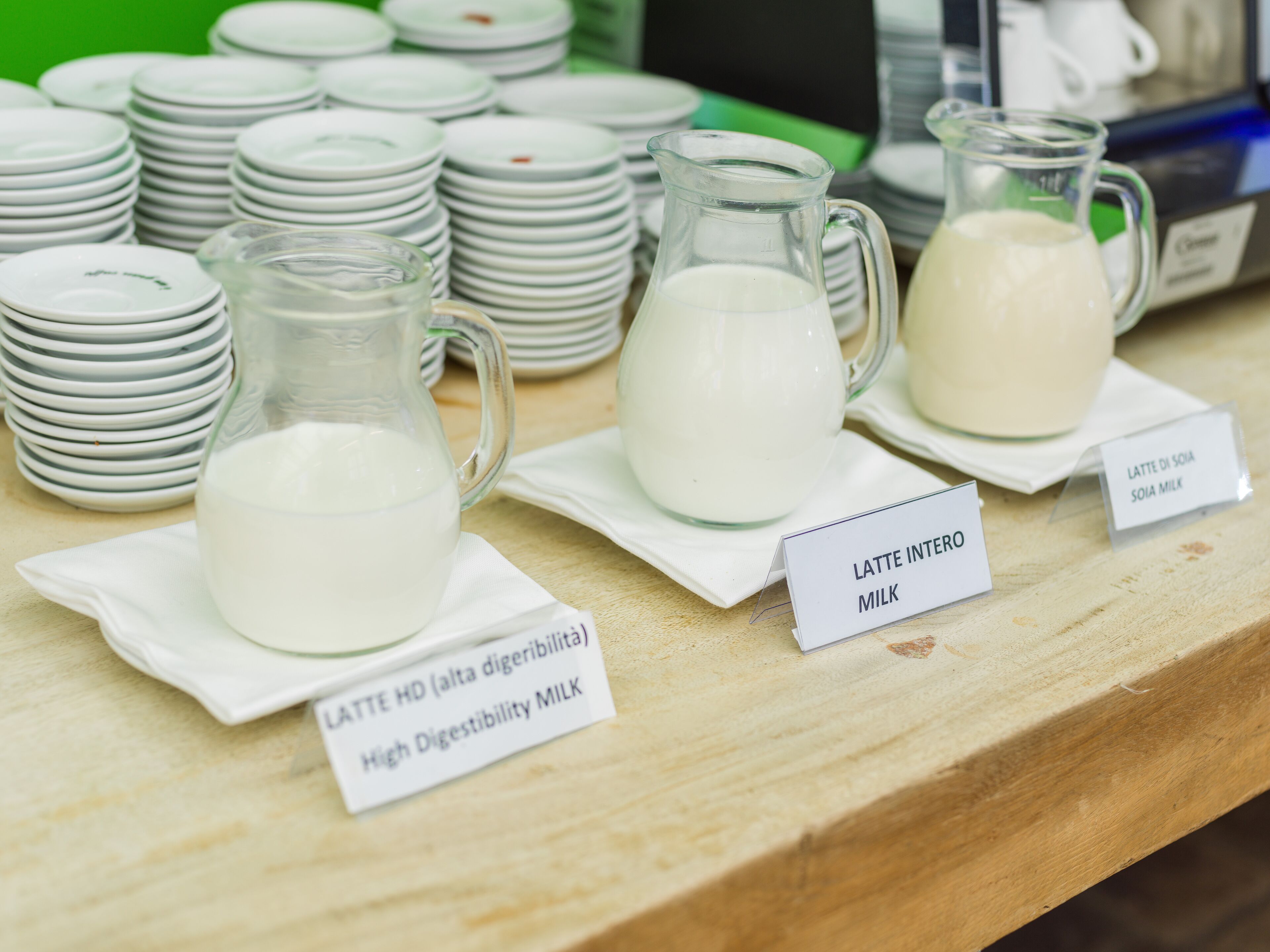 A display of milk products, including a pitcher labeled "LATTE HD (alta digestibilità MILK)" and a sign indicating "LATTE INTERO MILK".